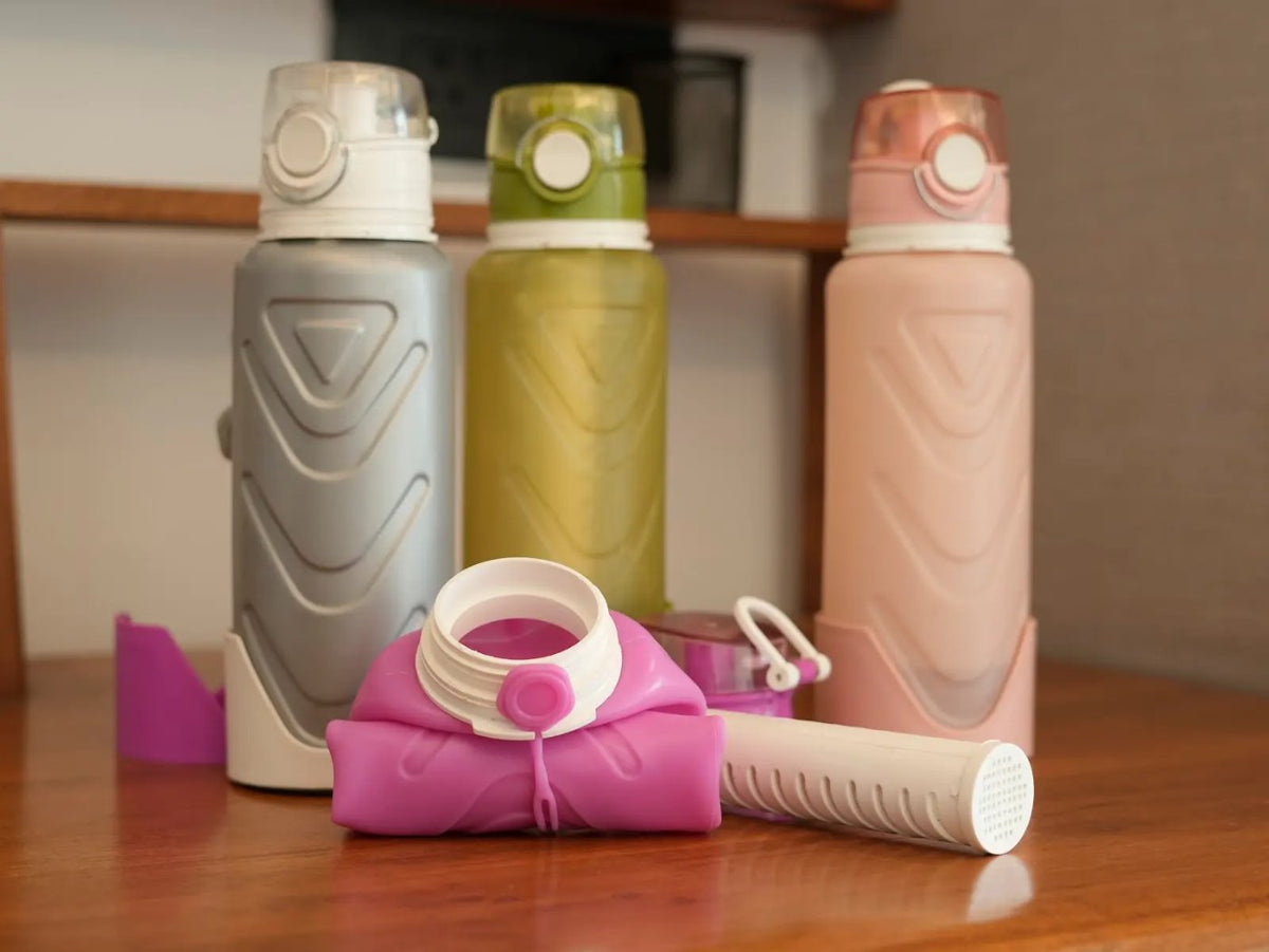 A folded Fllexibott beside three full bottles