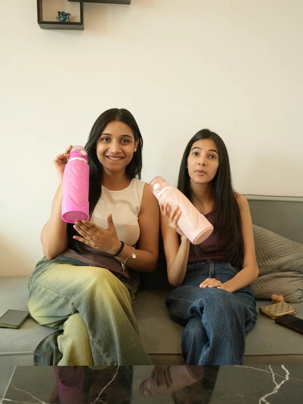 Two friends on a sofa holding Fllexibott bottles