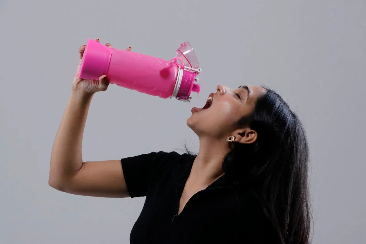 Squeezing a magenta Fllexibott to drink